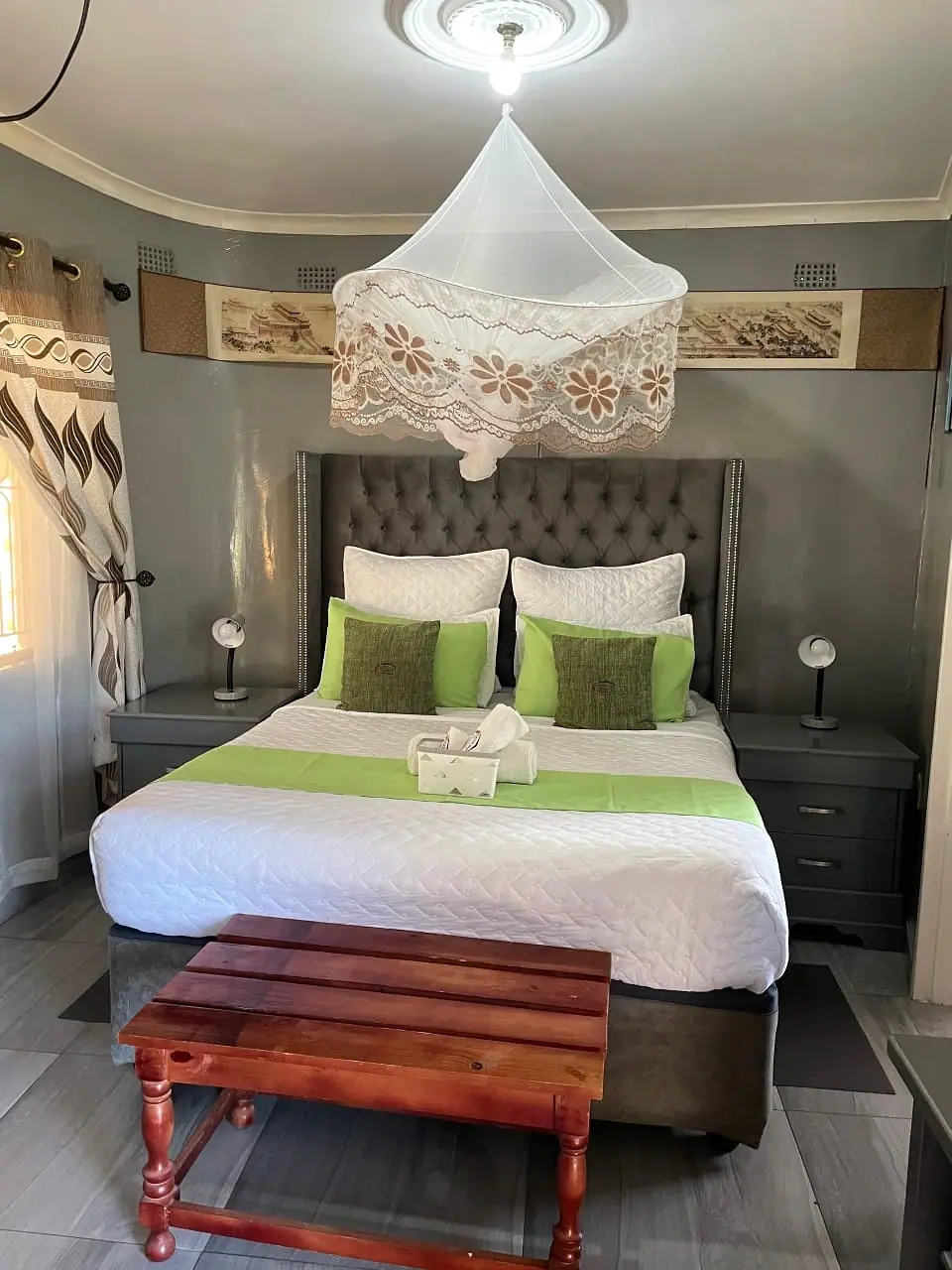 Front view of the canopy bed with a wooden bench at its foot
